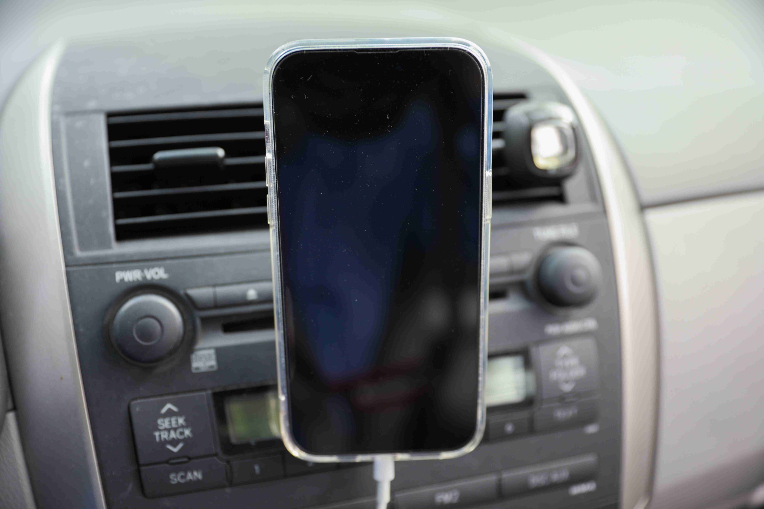 Smartphone mounted on a car air vent holder while charging