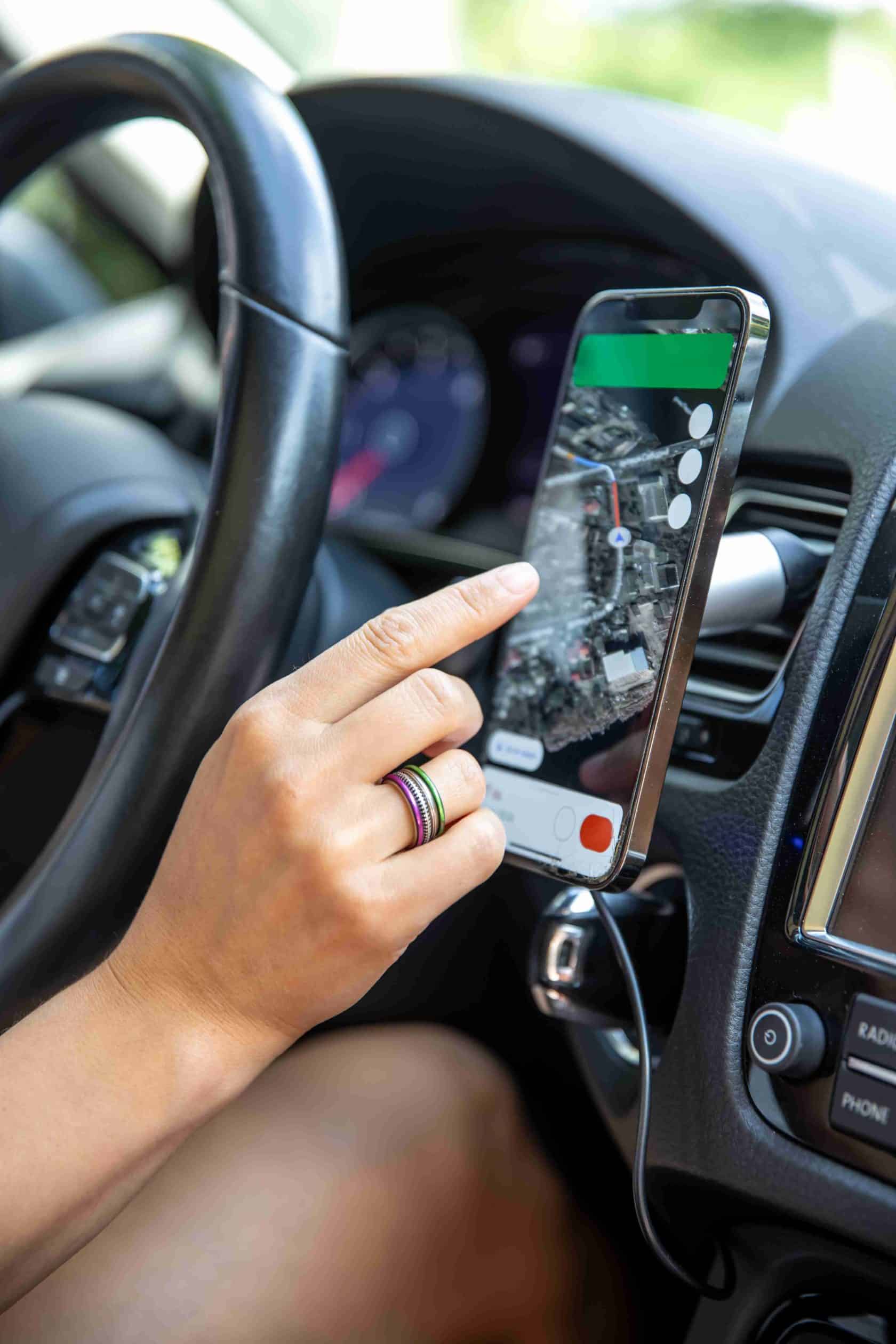 female-driver-hand-holding-phone-with-interface-navigator-screen